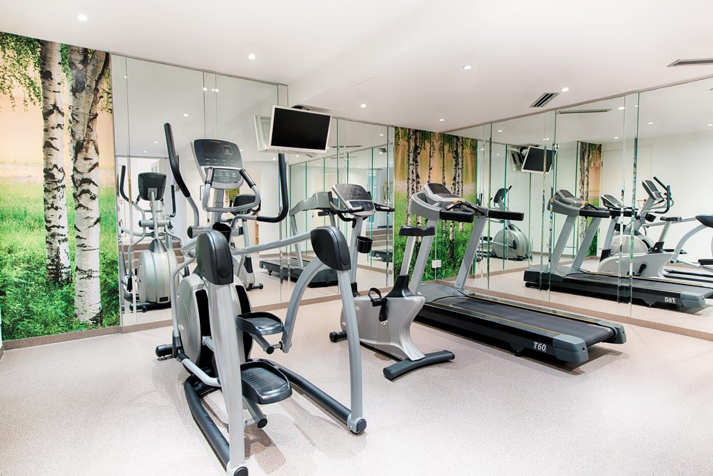 hotelschreiberhof-fitness.jpg Moderner Fitnessraum in einem Hotel mit verschiedenen Trainingsgeräten.